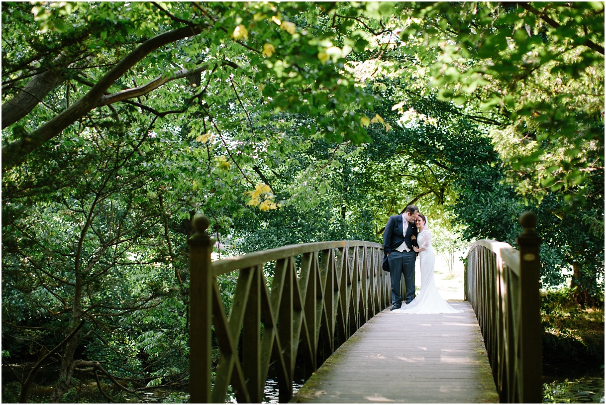 Bride and groom on bridge at Chiddingstone Castle