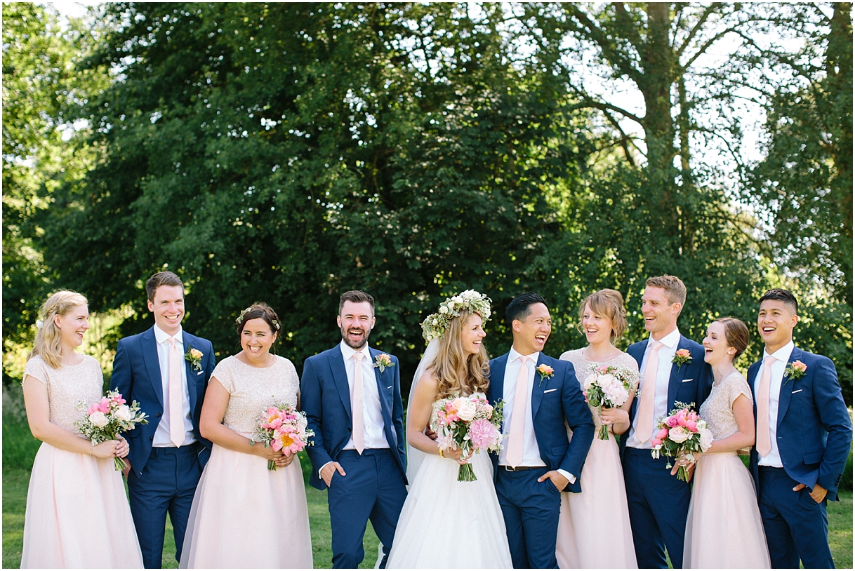 Bridesmaids in peach and gold with bride in flower crown