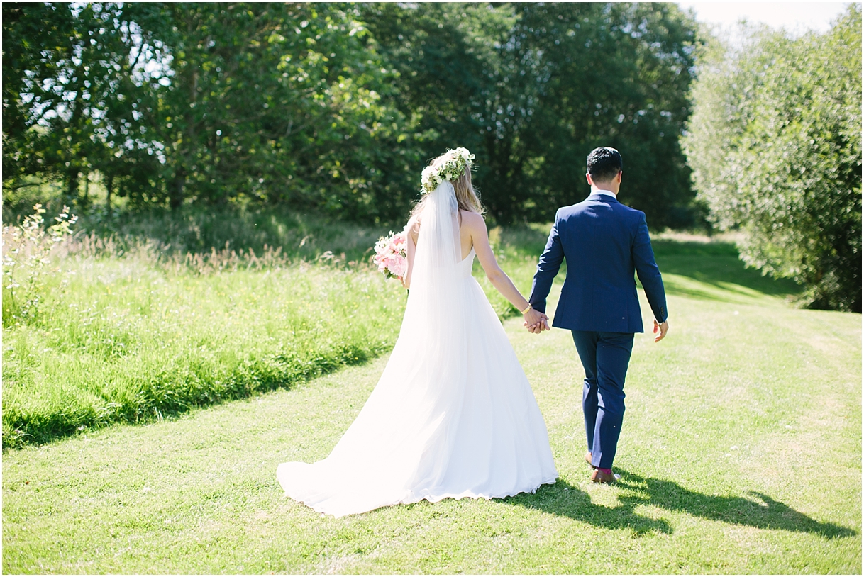 Bride and groom walking at Duncton Mill Fishery