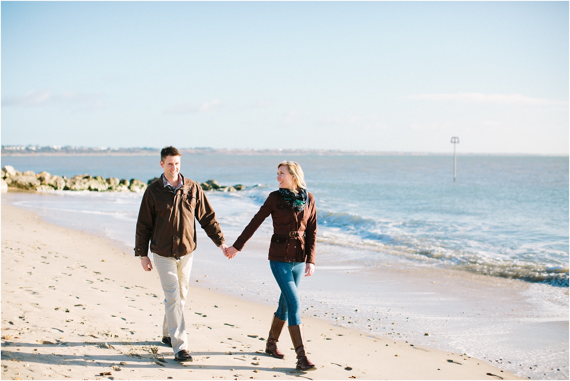 Couple walking along beach holding hands