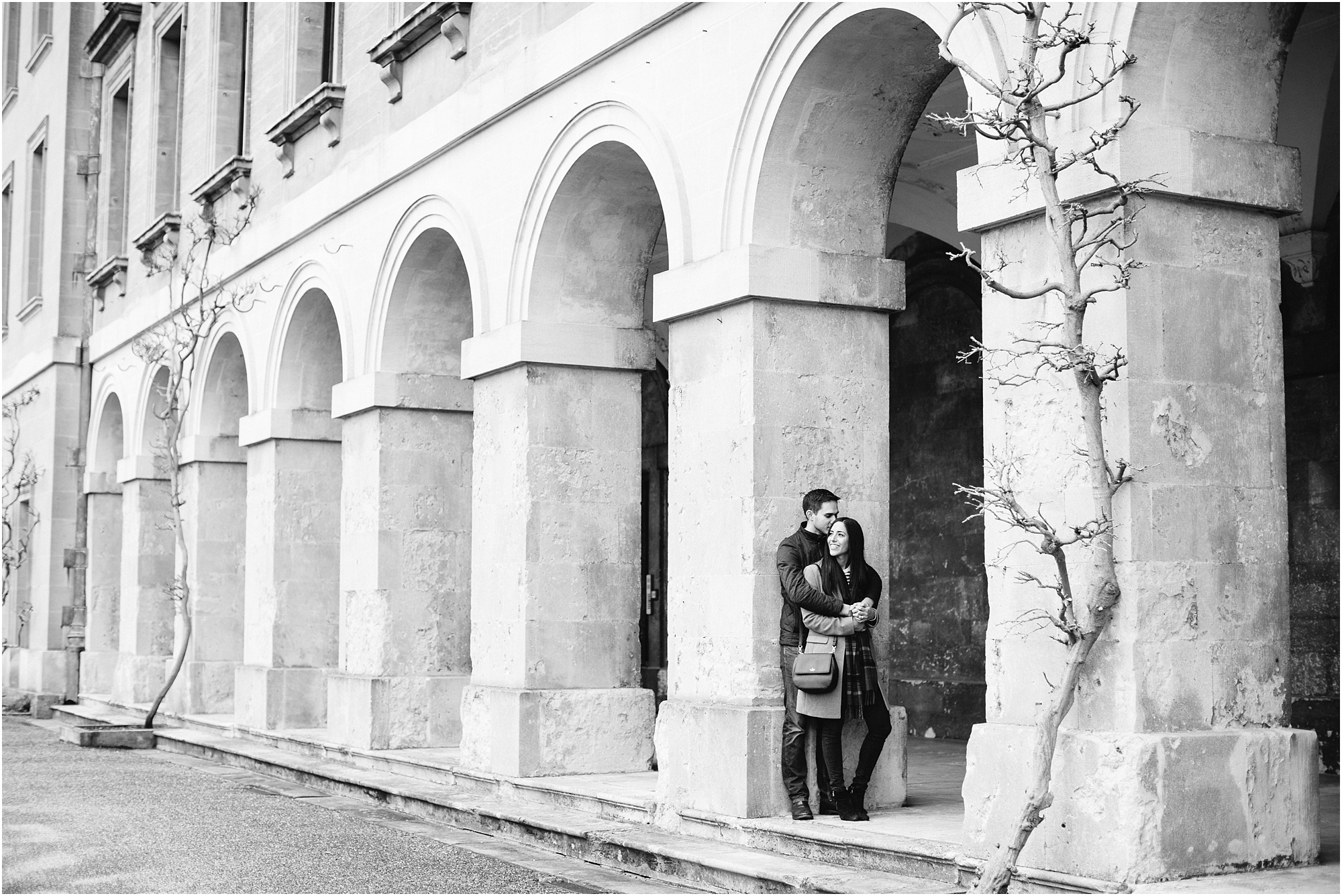 black and white photo of couple cuddling in a archway
