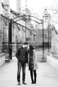 black and white photo of couple kissing in front of gate at Magdalen College Oxford