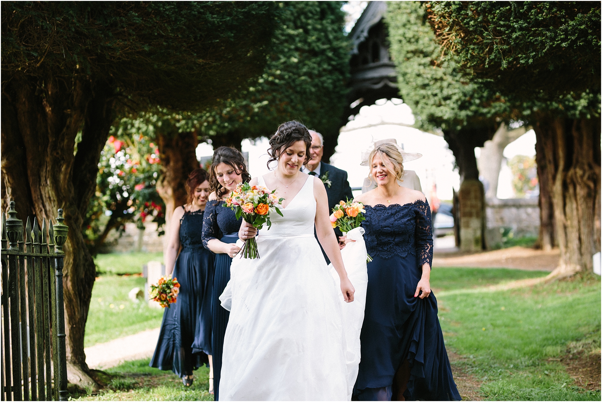 bride walking to church with bridesmaids