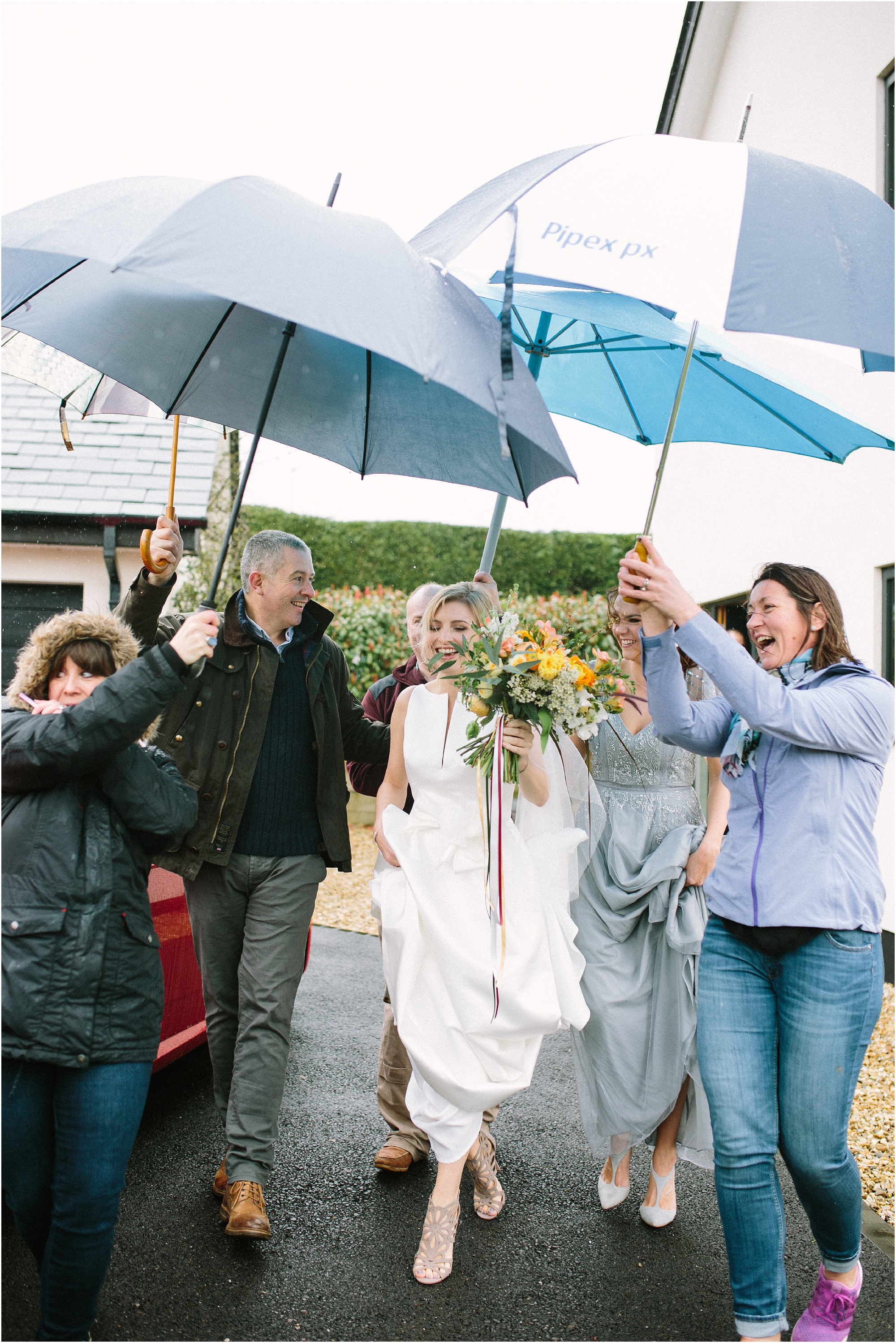 bride in rain with umbrellas