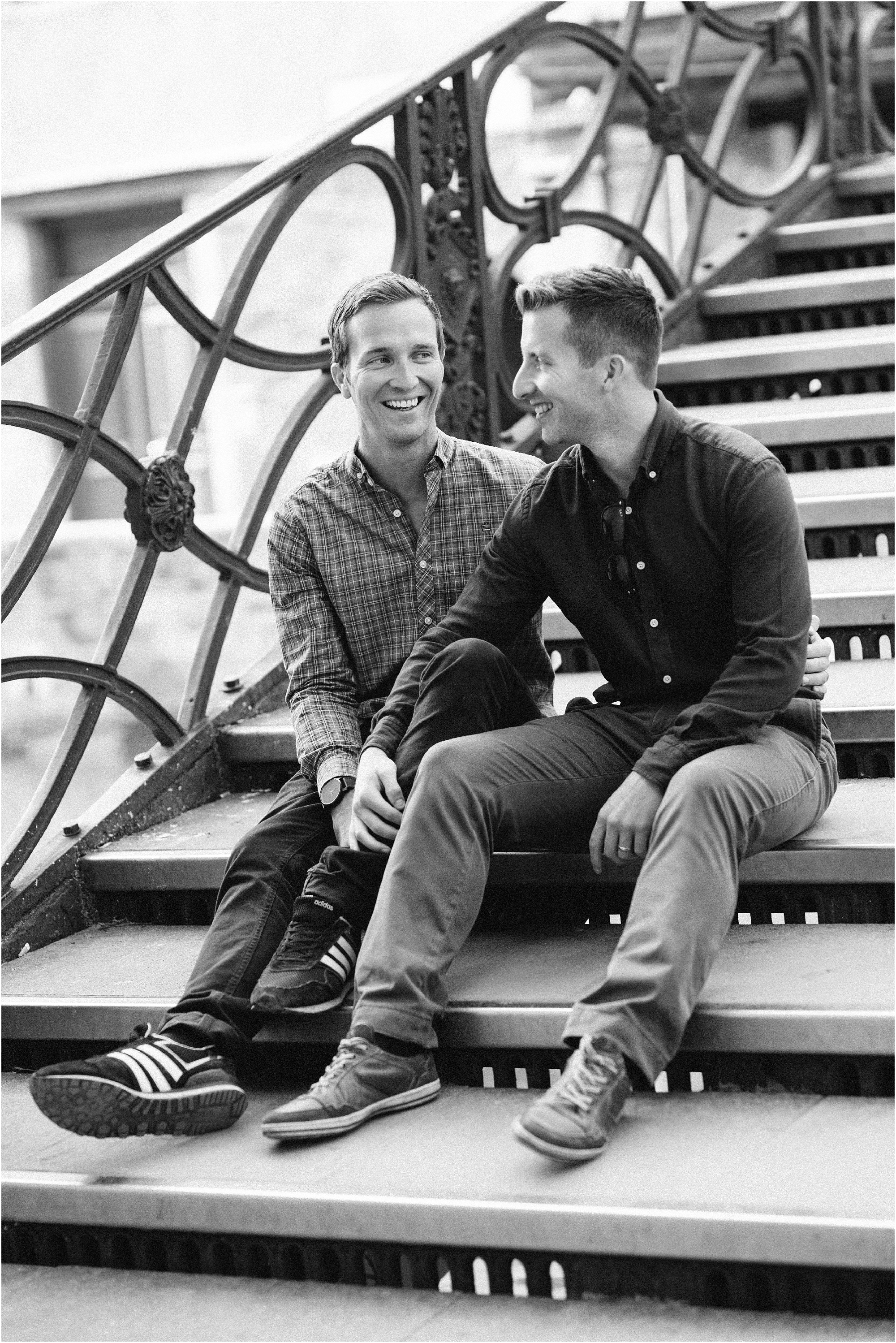 Male gay couple sitting on Venice bridge