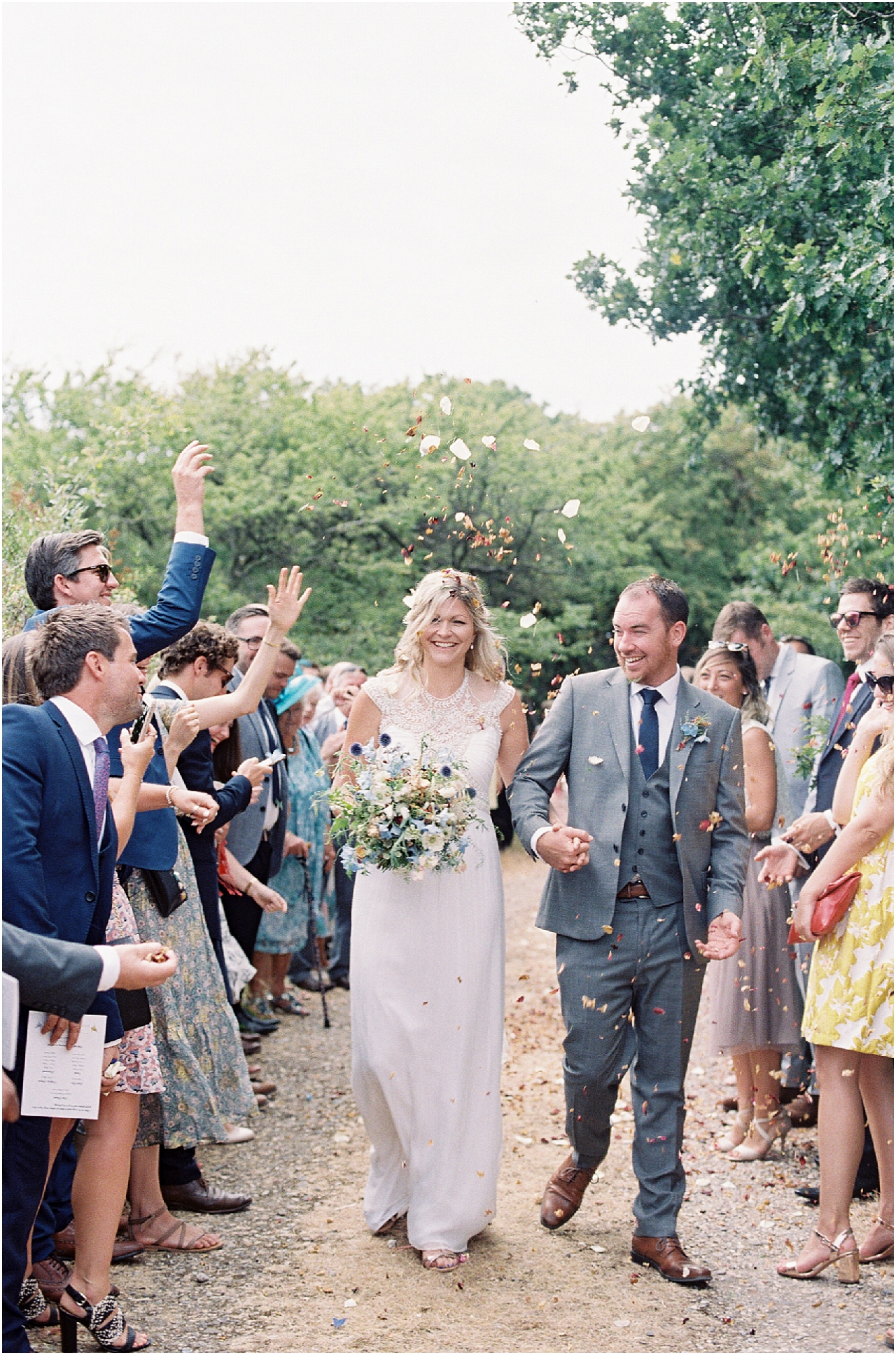 Bride and groom walking through confetti at Tournerbury Woods