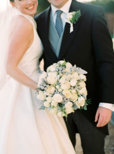 Close up photograph of white and green winter wedding bouquet with white and green