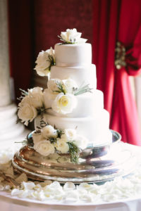 White three tier wedding cake decorated with white roses at Goodwood House
