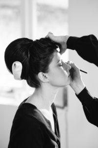 Bride having make up done on wedding morning