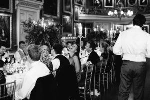 Black and white photograph of guests laughing at Goodwood House wedding