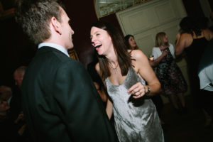 Couple dancing and laughing in the evening of a Goodwood House wedding