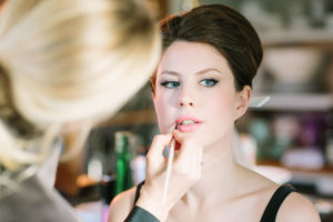 Make up artist doing bride's lipstick on morning of Goodwood House wedding