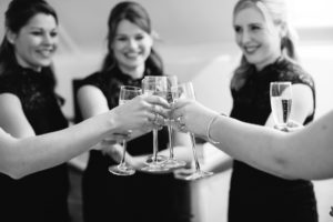 Black and white photograph of bridesmaids toasting on wedding morning