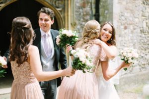 Bride and groom higging bridesmaids outside church after wedding ceremony