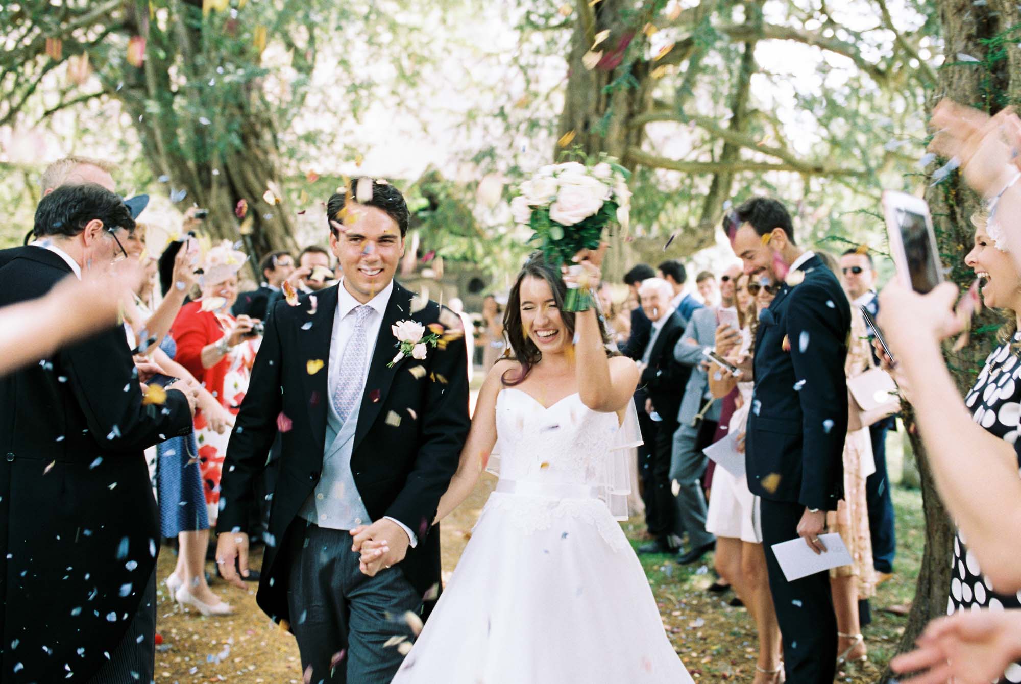 Bride and groom laughing in wedding confetti
