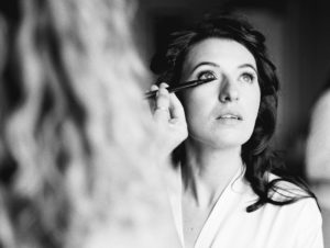 Black and white photograph of bride having her wedding make up done at Stansted House