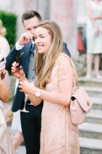 Wedding guest in peach dress laughing during wedding reception