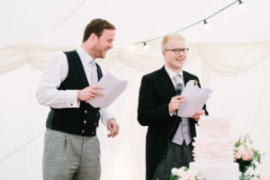 Best men delivering funny speech in wedding marquee