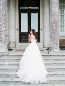 Beautiful elegant bride on the steps of Stansted House