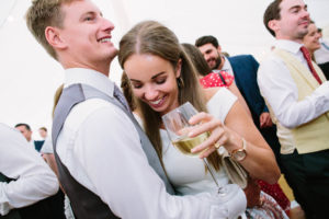 Wedding guests dancing holding a glass of white wine
