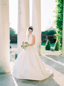Bride standing in the entrance of Goodwood House wearing Jesus Peiro wedding dress