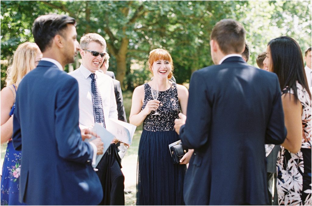 Wedding guests laughing at Chiddingstone Castle 