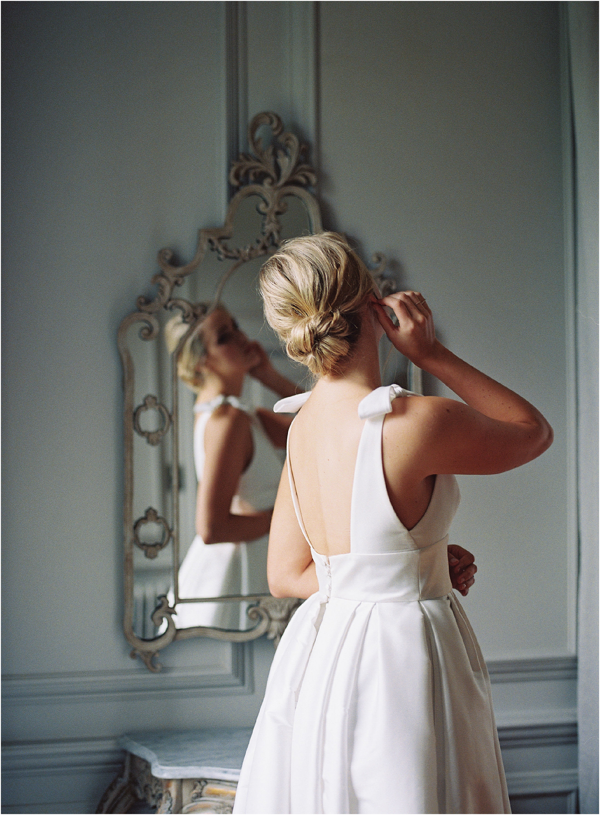View of bride looking in the mirror on the morning of her Thorpe Manor wedding