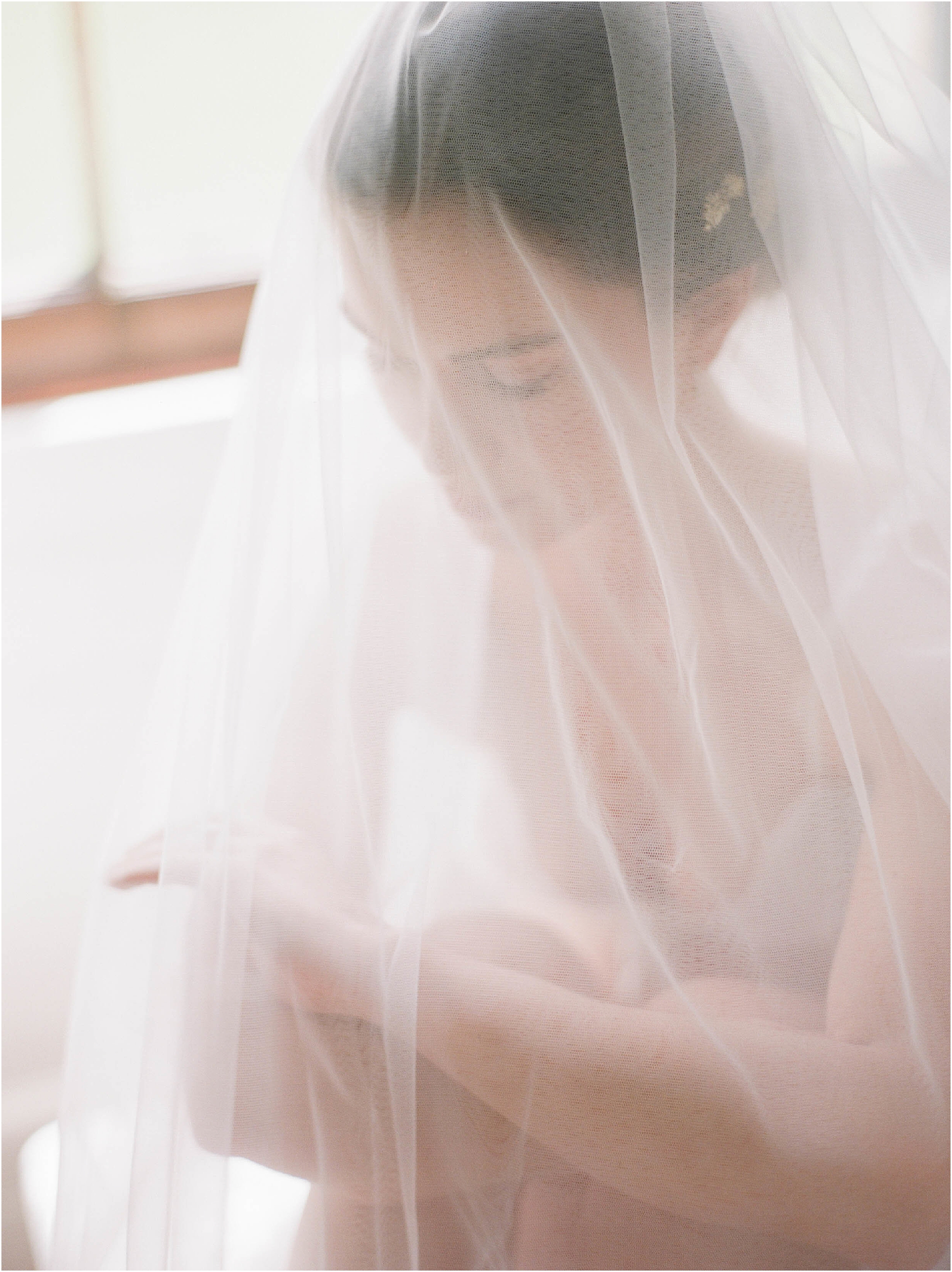 Dream photograph of bride with veil over her face