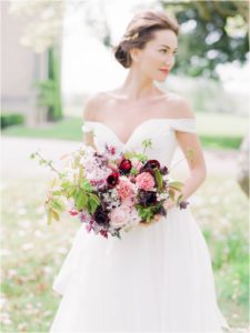 Bride holding bouquet of maroon and pink
