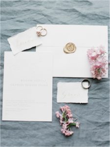 Wedding stationery and rings on grey linen
