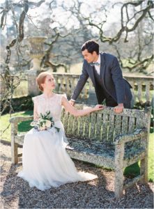 elegant couple looking at each other on bench at wedding