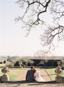 Elegant bride and groom sitting on the steps looking into the distance