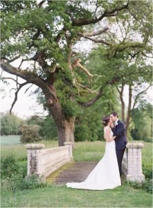 bride and groom kissing on the bridge in the grounds of St Giles House
