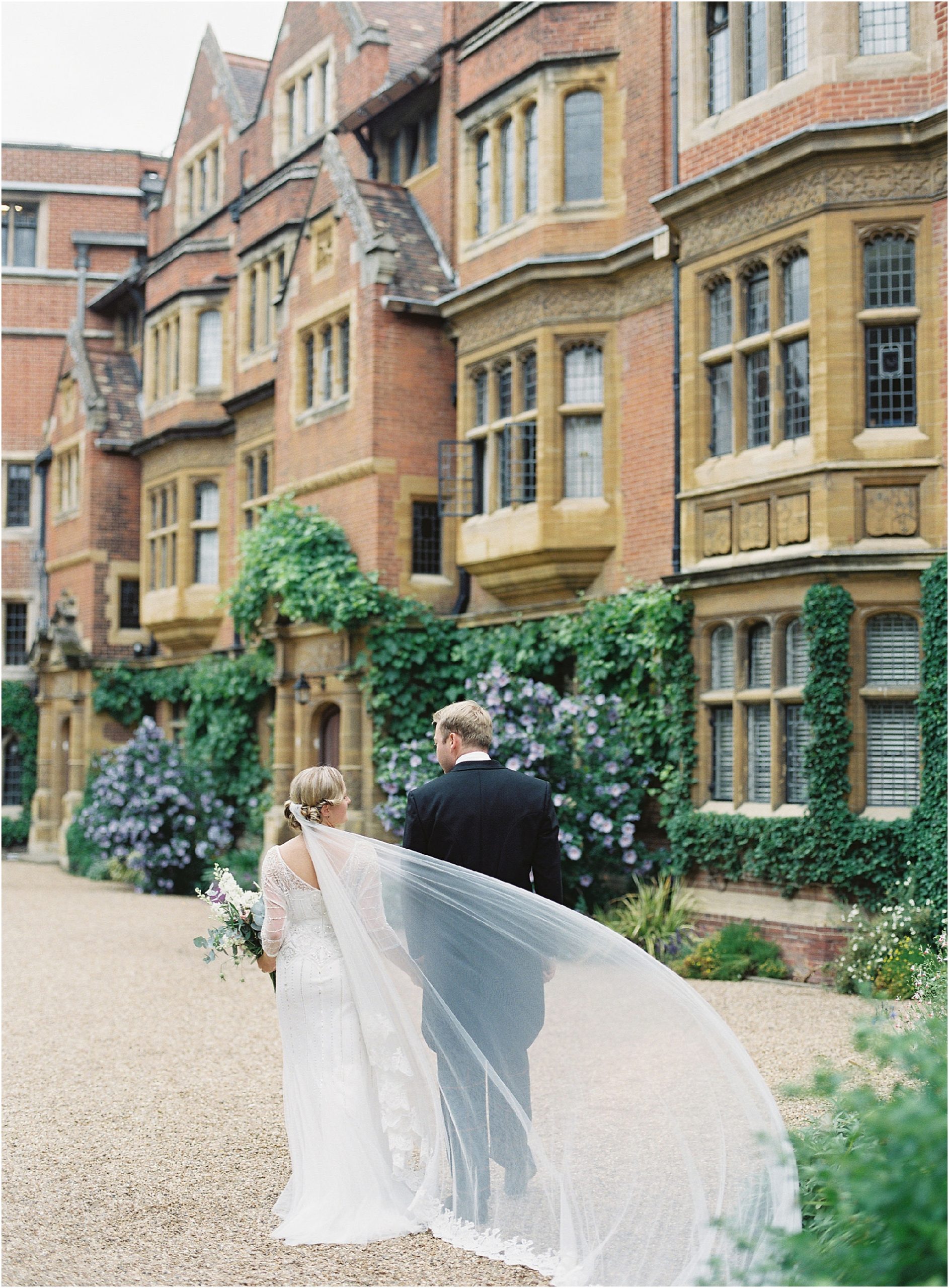 Bride and groom walking away in the grounds of Trinity Hall Cambridge