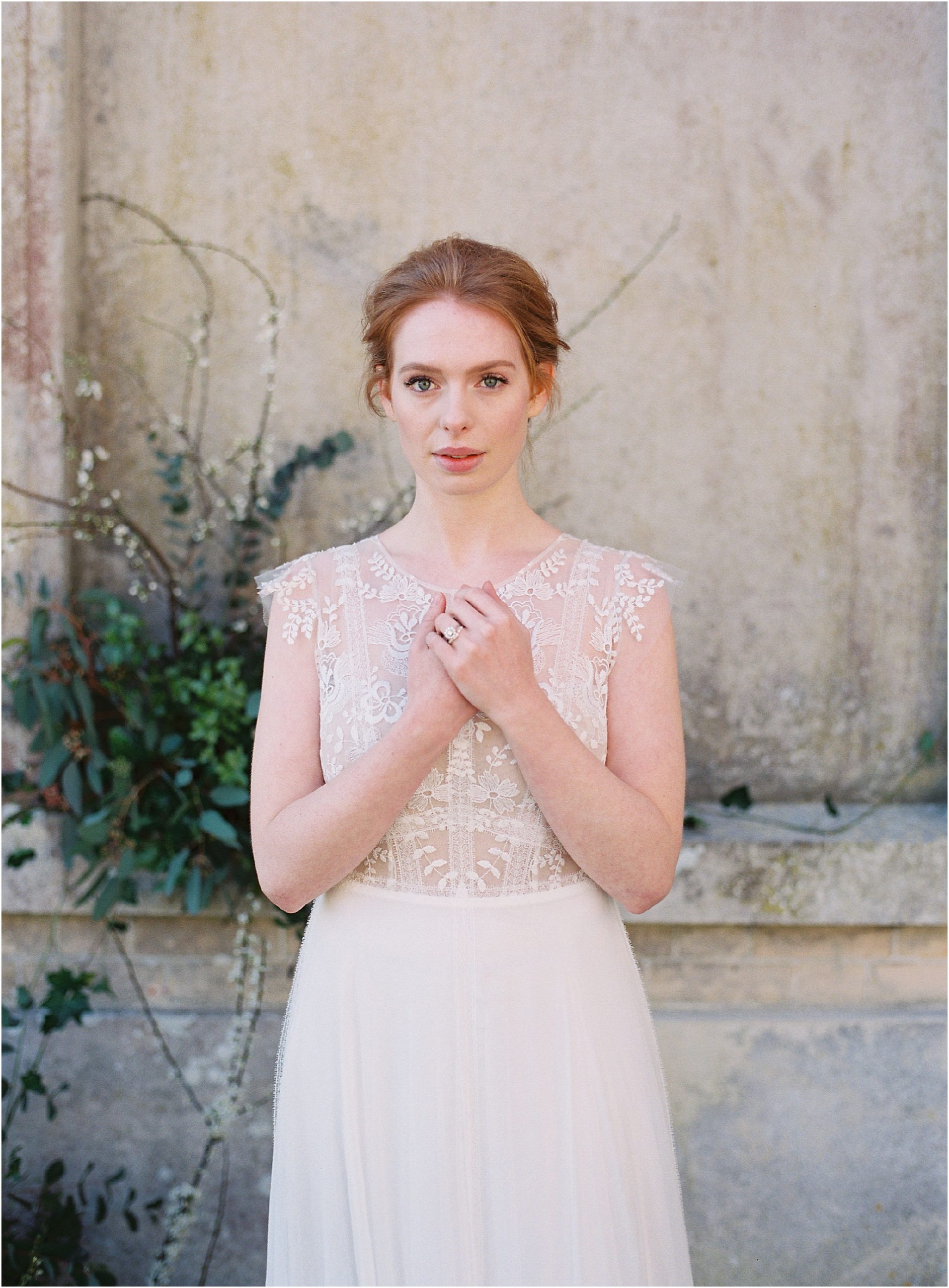 Bride with red hair in lace delicate wedding dress