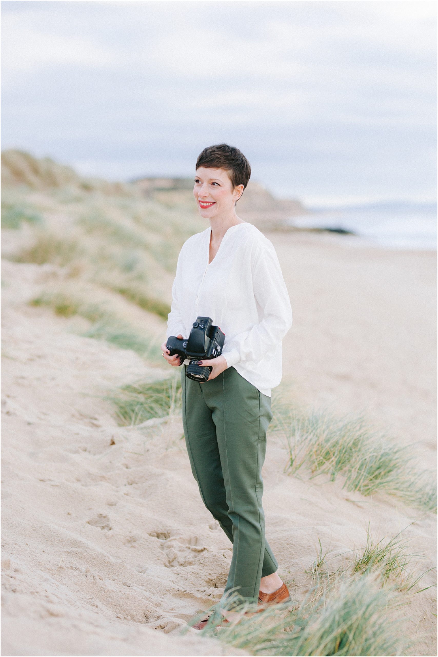 Fine art film wedding photographer Camilla standing on a Dorset beach