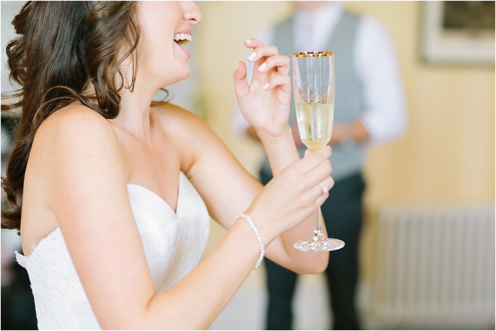 Bride holding glass of champagne and laughing