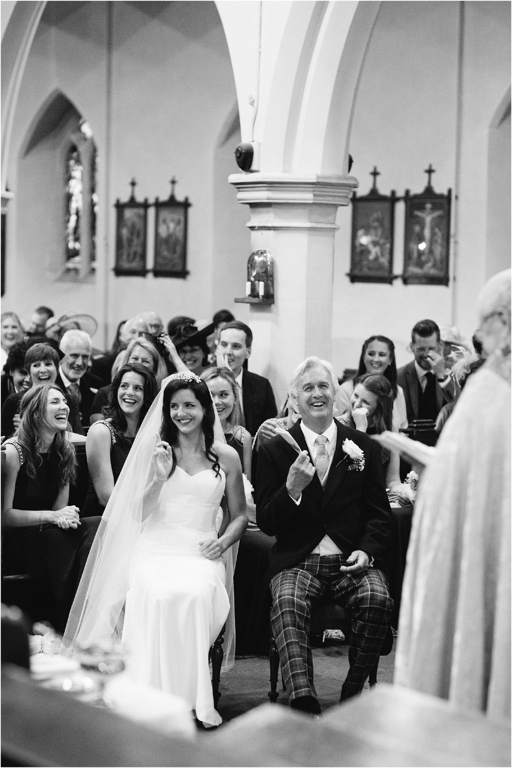 Wedding party laughing during church wedding ceremony