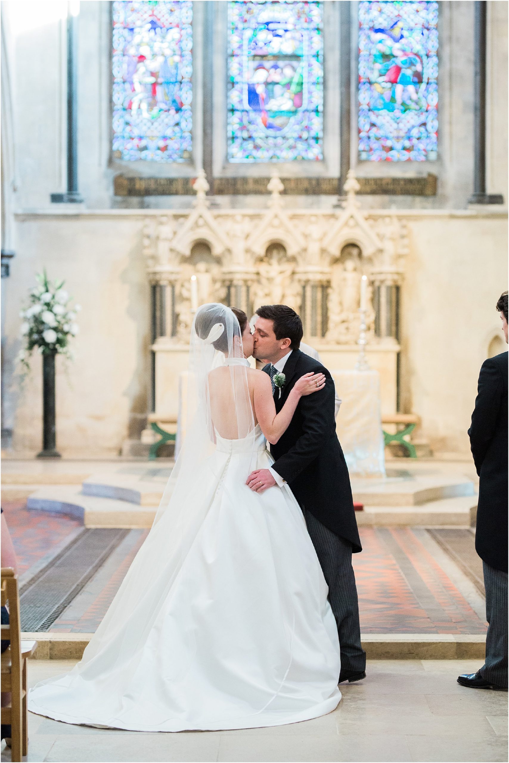 Bride and groom having first kiss at Boxgrove Priory wedding