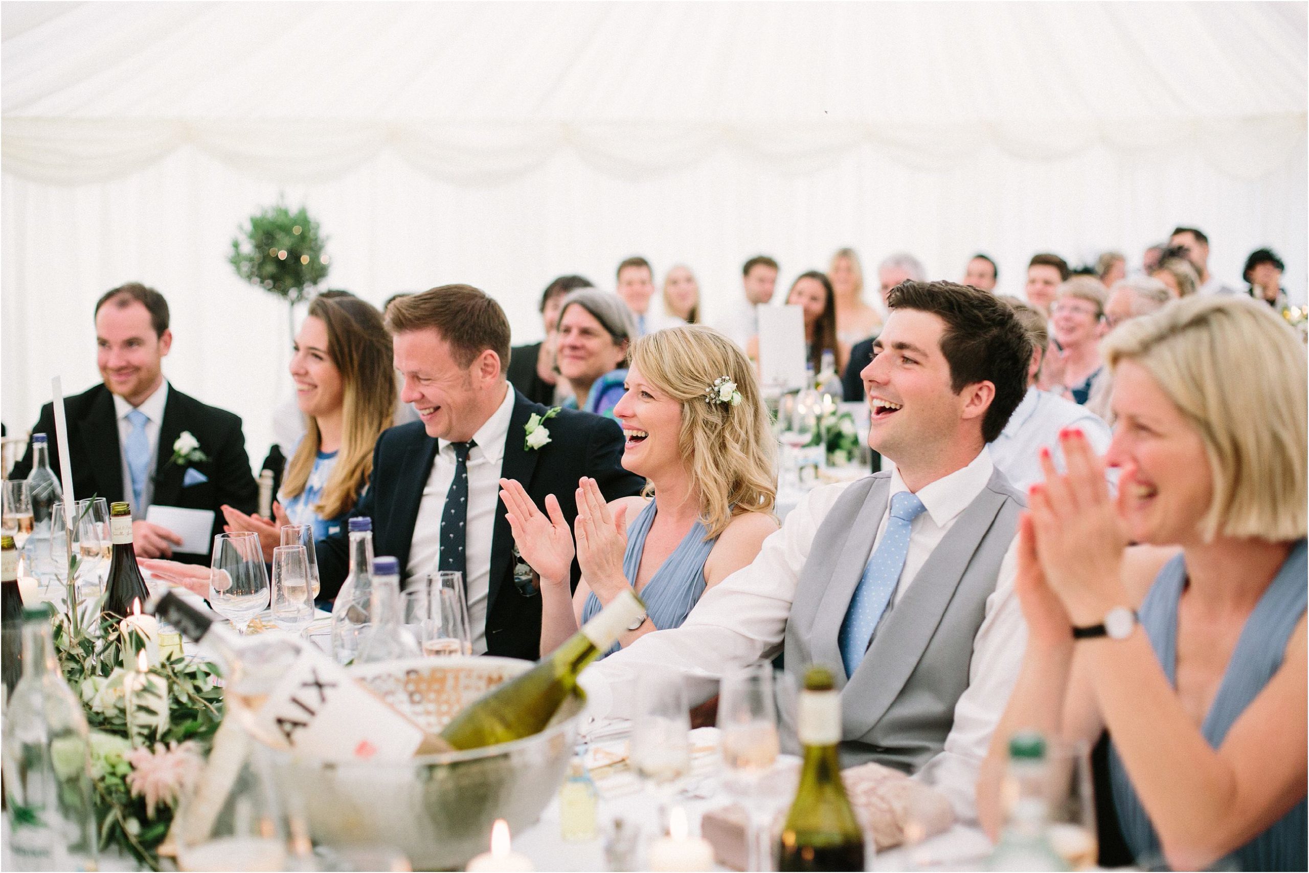 Guests laughing during wedding speeches 