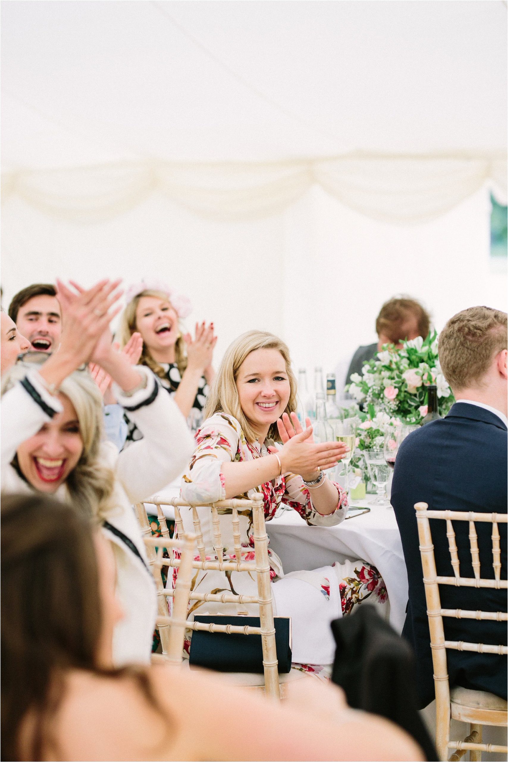 Wedding guests smiling and clapping during speeches