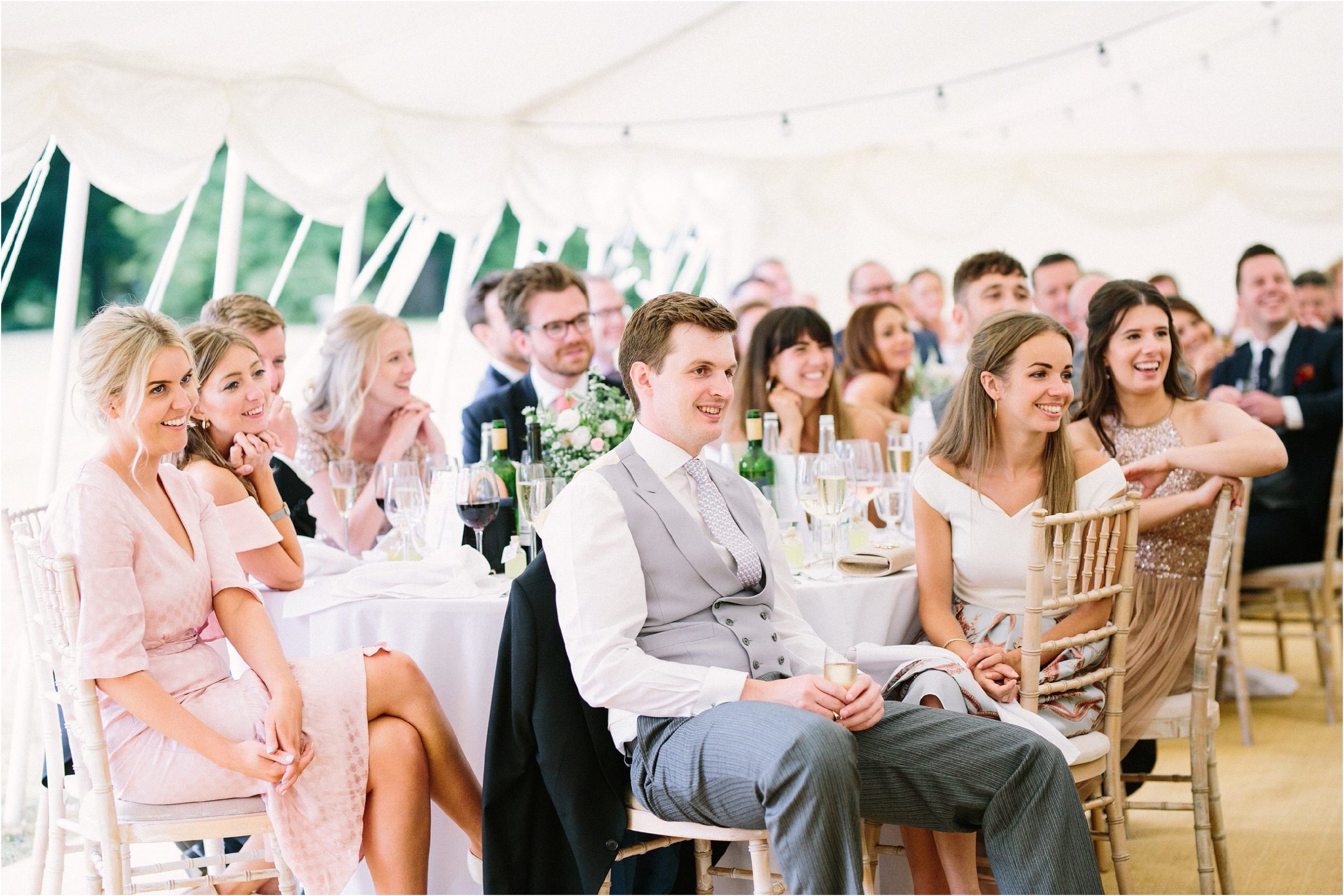 Guests smiling listening to wedding speech