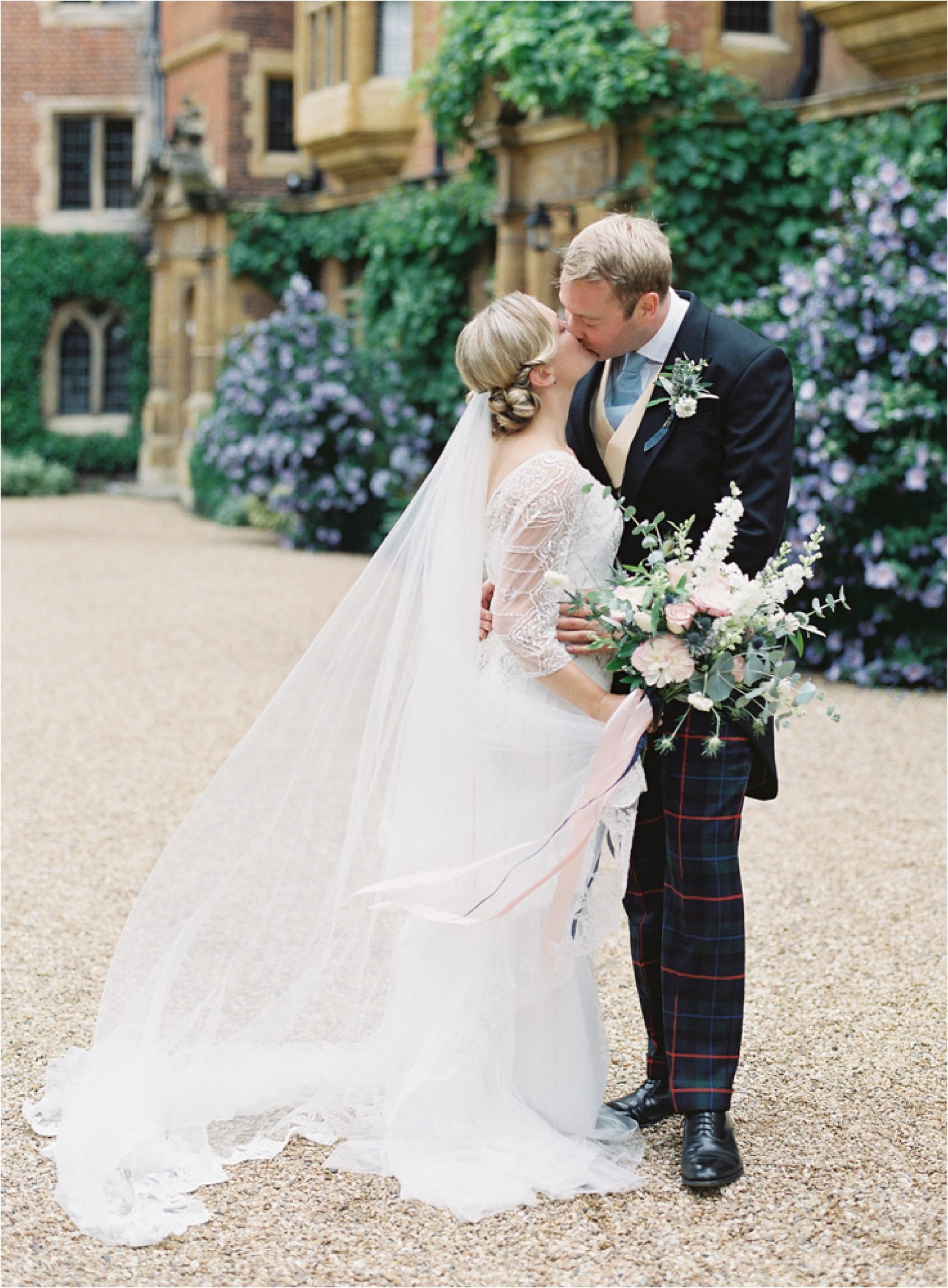 bride and groom kissing during elegant English wedding at Trinity Hall Cambridge