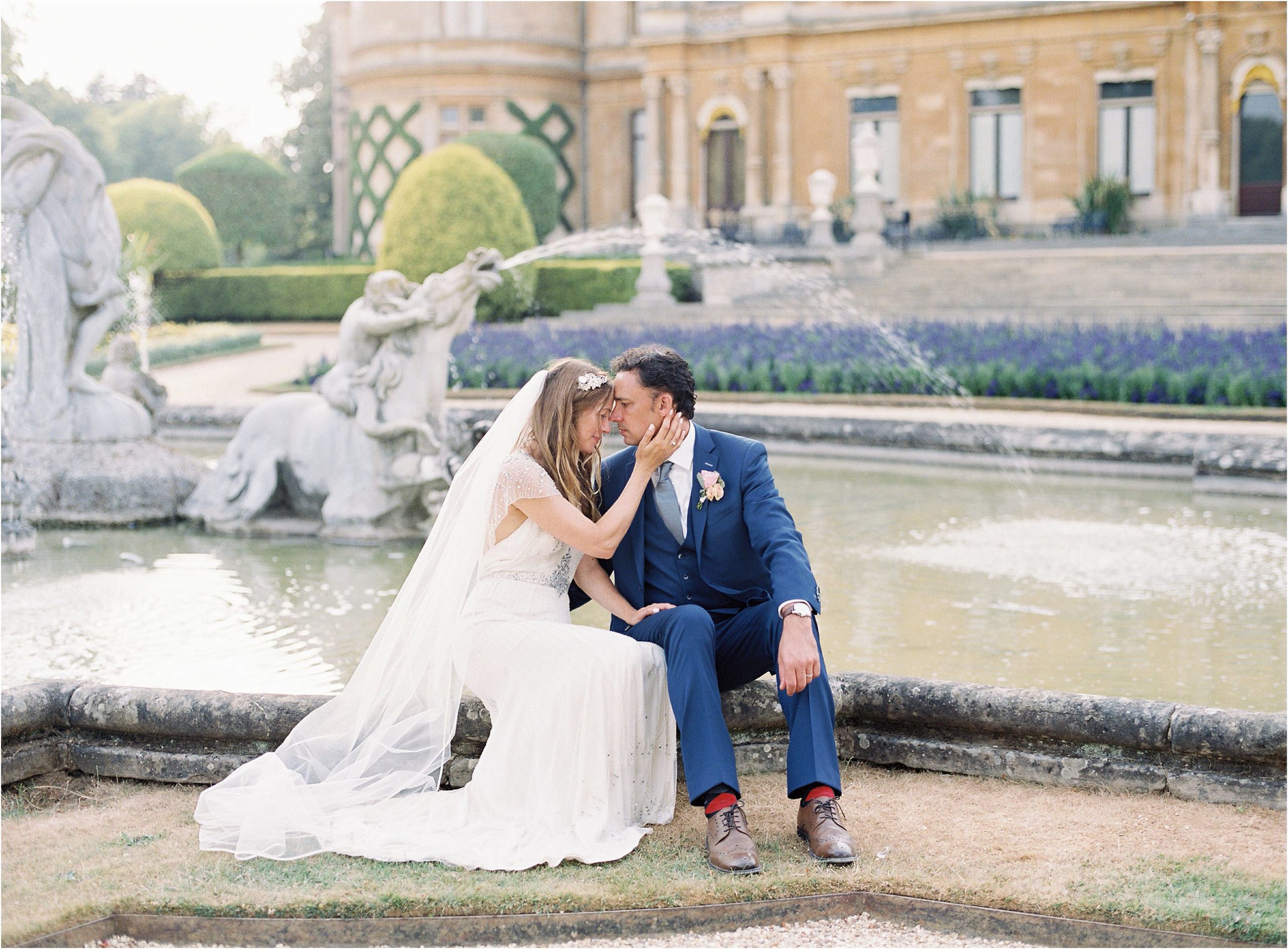 couple sitting beside fountain at Waddesdon Manor wedding