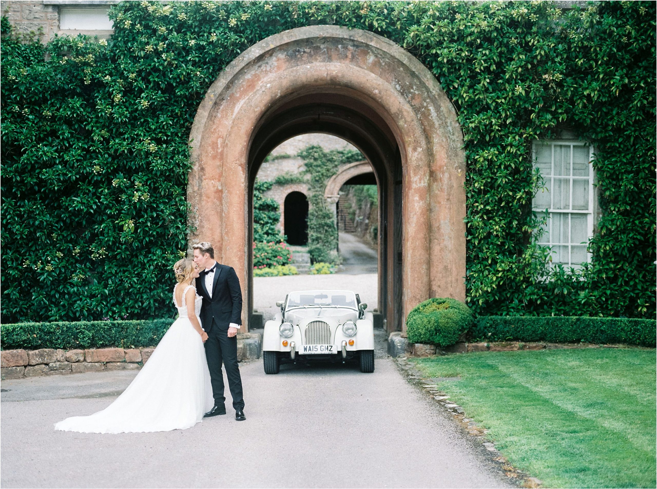 Bride and groom with vintage wedding car