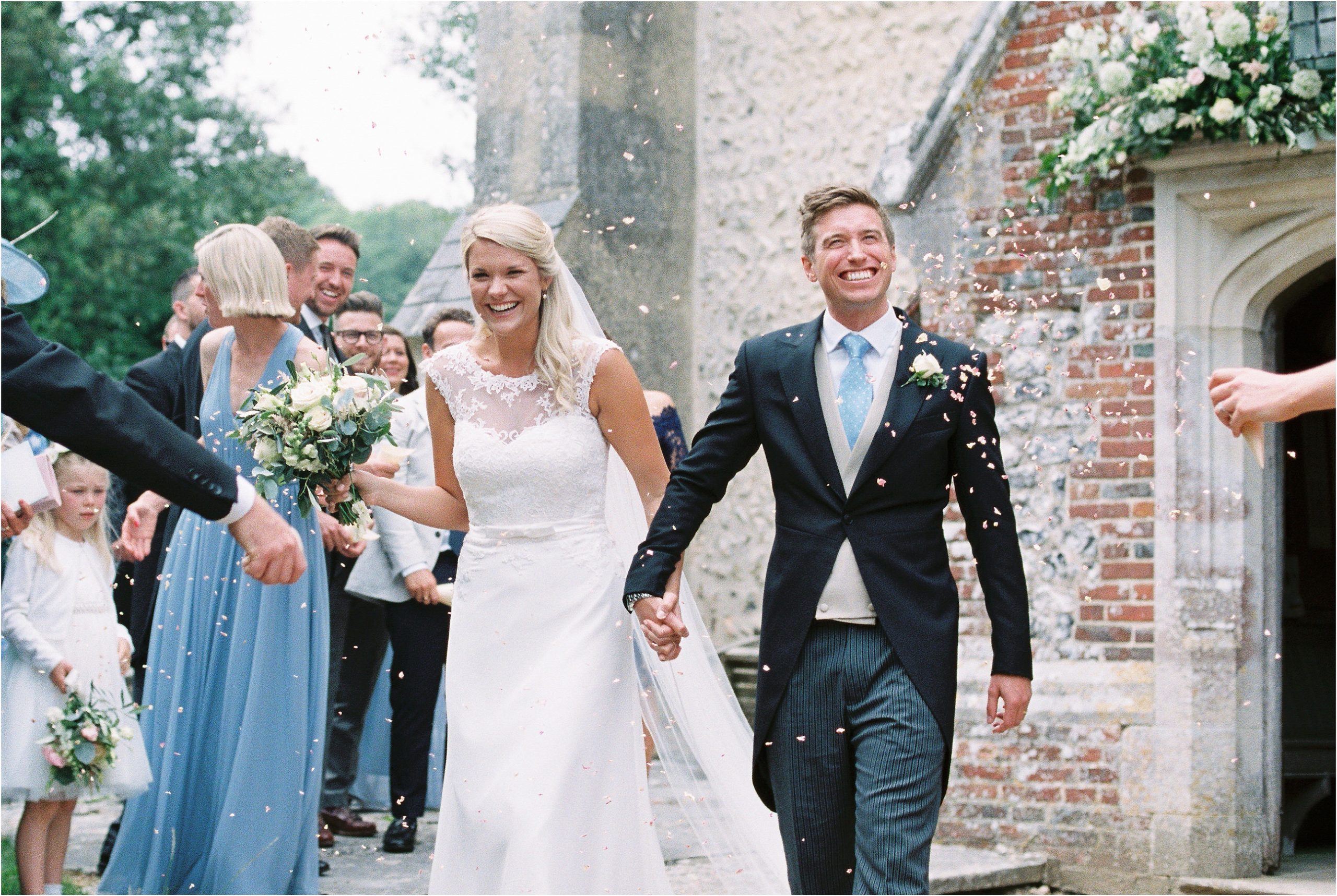 Bride and groom walking through confetti at luxury wedding