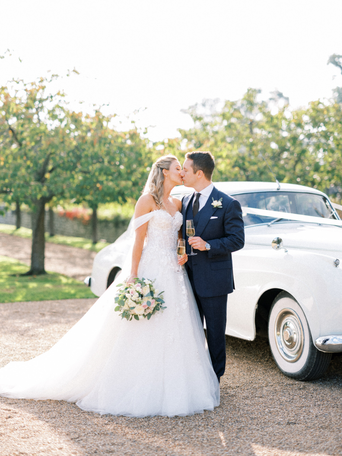 bride and groom with white Rolls Royce at Cowdray House wedding