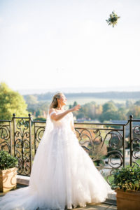 bride throwing bouquet from balcony at Cowdray House luxury wedding venue