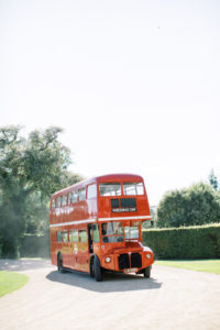Guests arriving on London bus to Goodwood House Summer Wedding