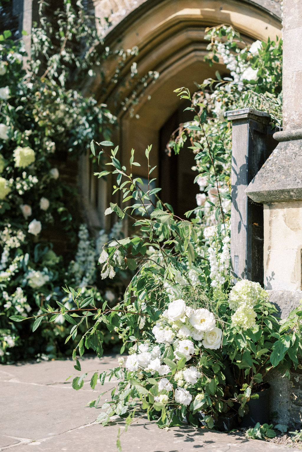 Floral arch at church service before garden marquee wedding greens white and blush